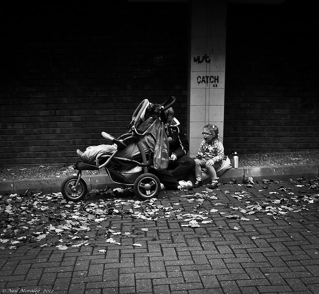 a photo of a woman on the street with her two babies