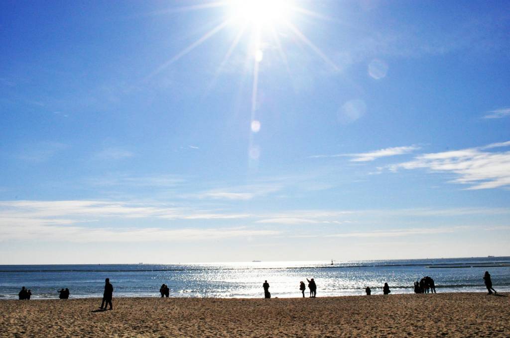 Photo of a sunny sky and people on beach.