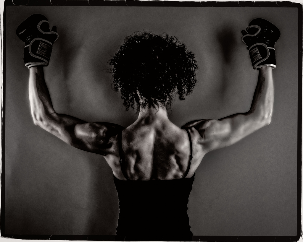 A strong women holding her arms up.