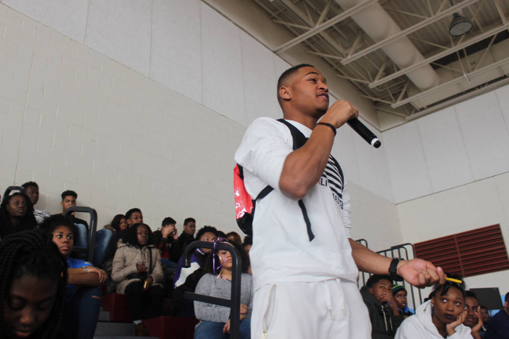 Photo of a young man speaking into a microphone.