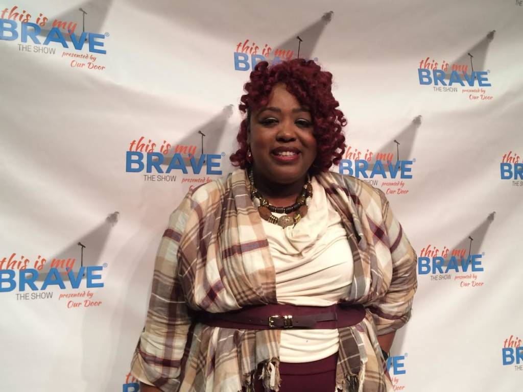 Tonyia Renee stands in front of a banner that says "This Is My Brave"