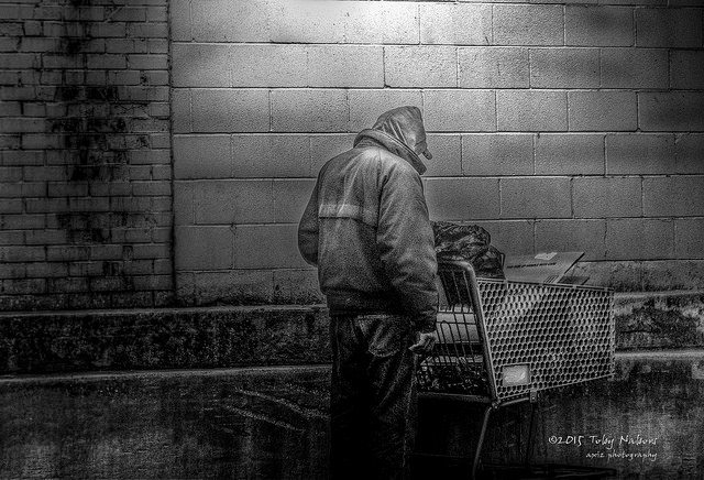 A homeless man with his belongings in a cart