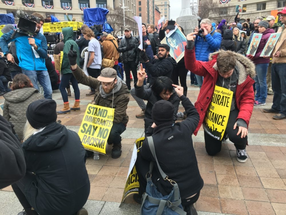 Protesters are kneeling and holding up fists at Navy Memorial.