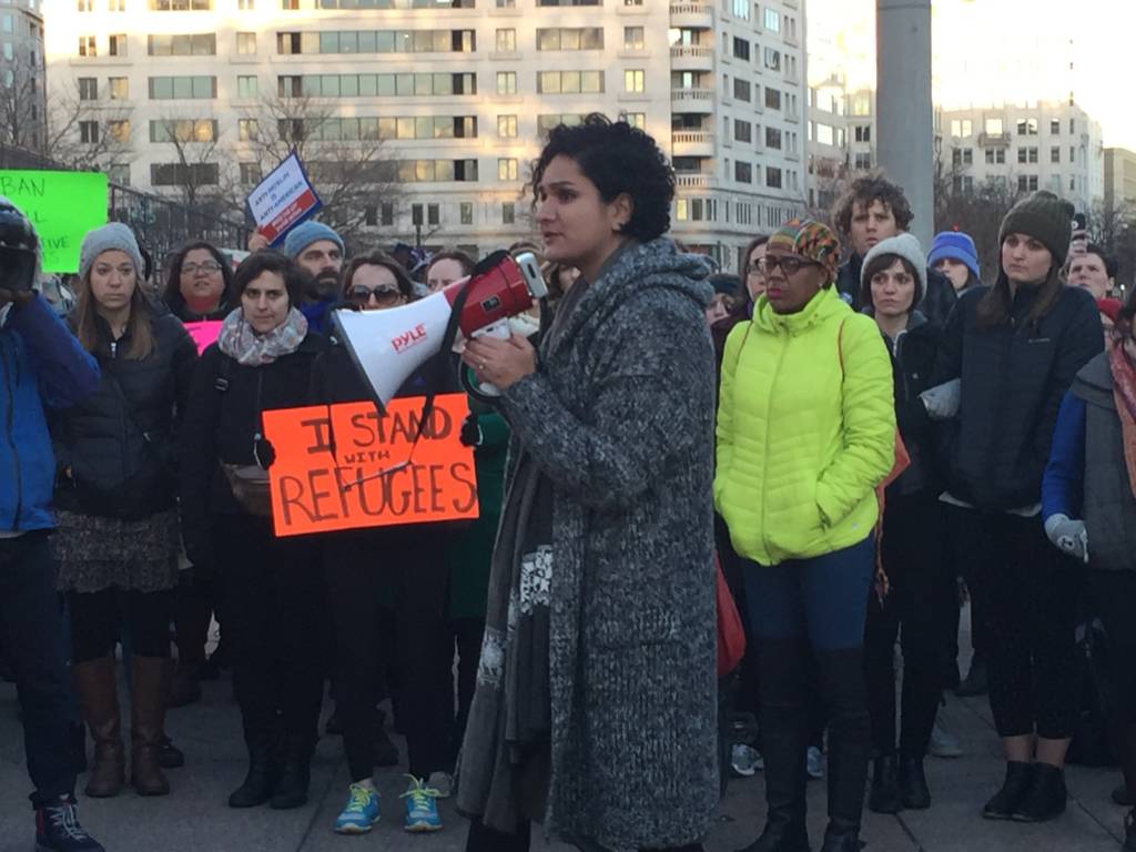 Noor Mir speaks to protestors at the rally.