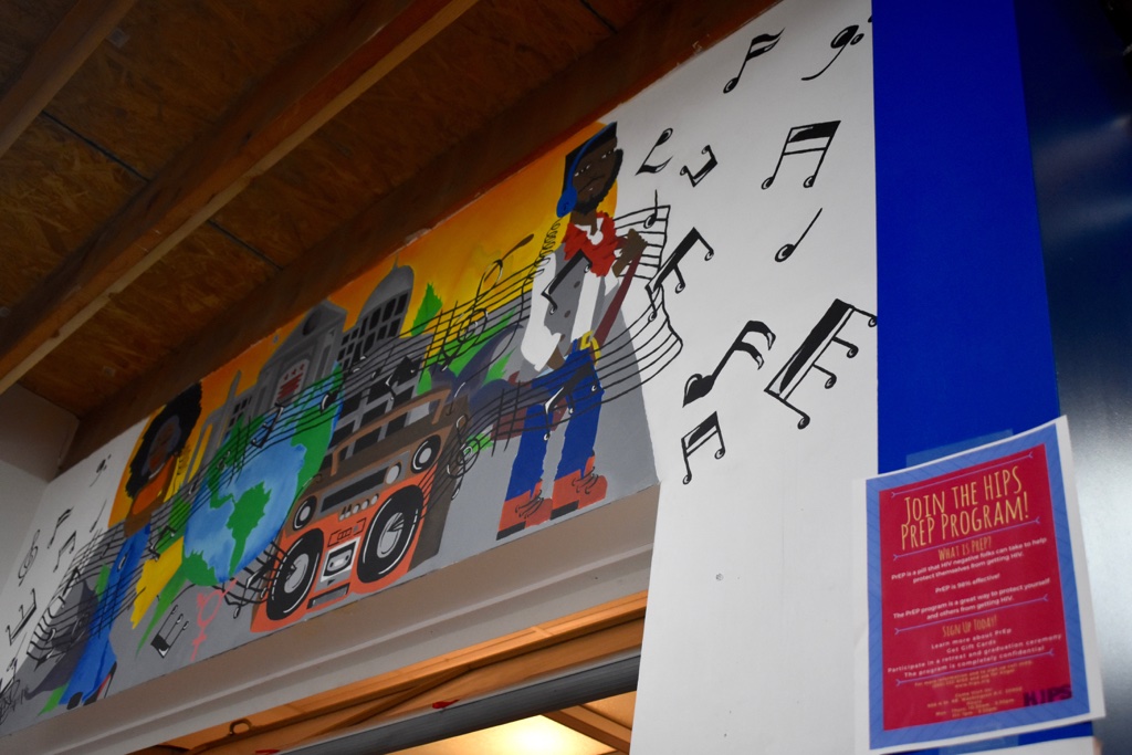 A mural above a doorway alongside a flier that reads "Join the HIPS PrEP Program."