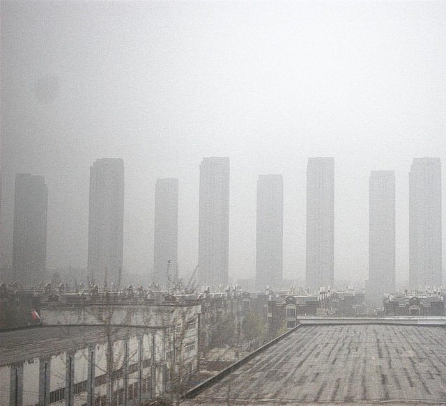Picture of a neighborhood leading up to a smoggy city.