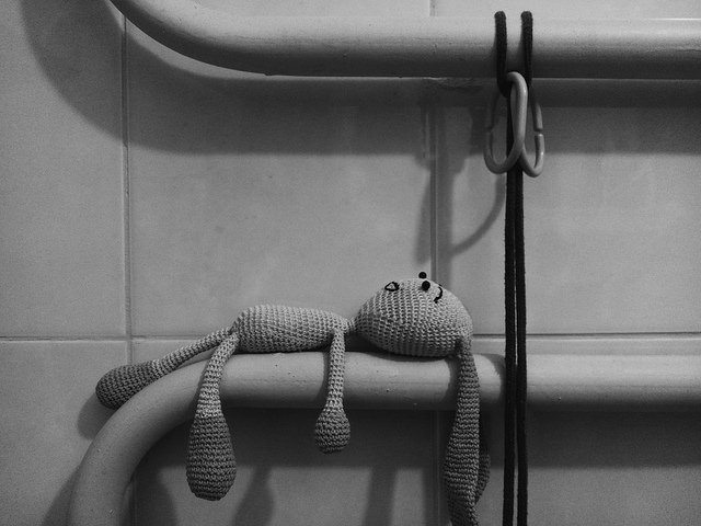 A doll laying on a pipe in a tunnel
