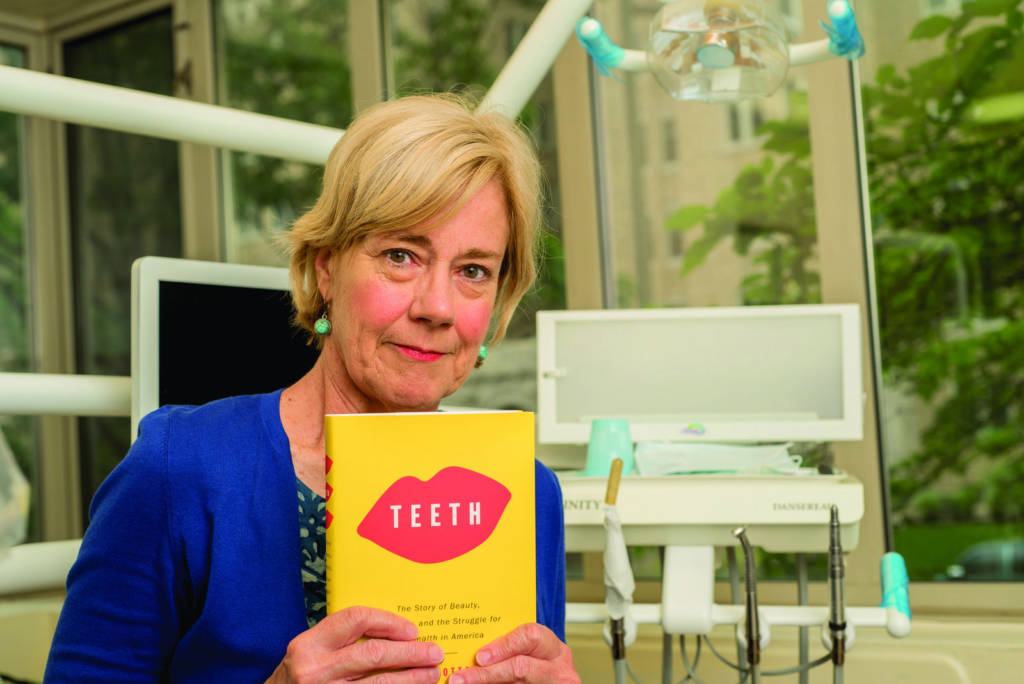 A photo of Mary Otto holding her book in a dental office.