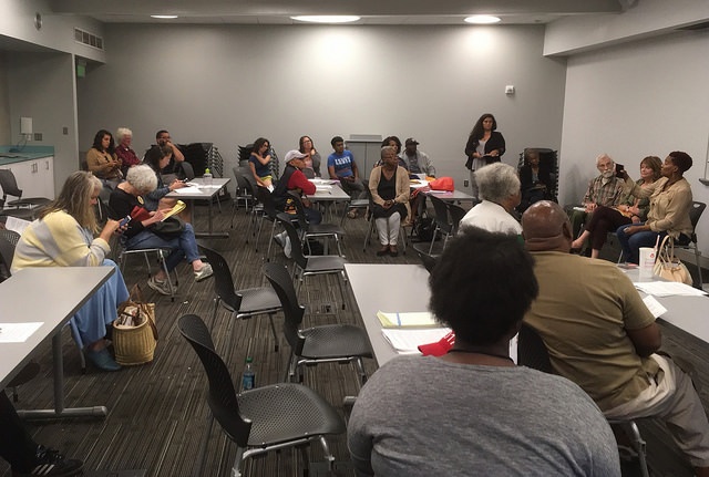People at the meeting sit around a room