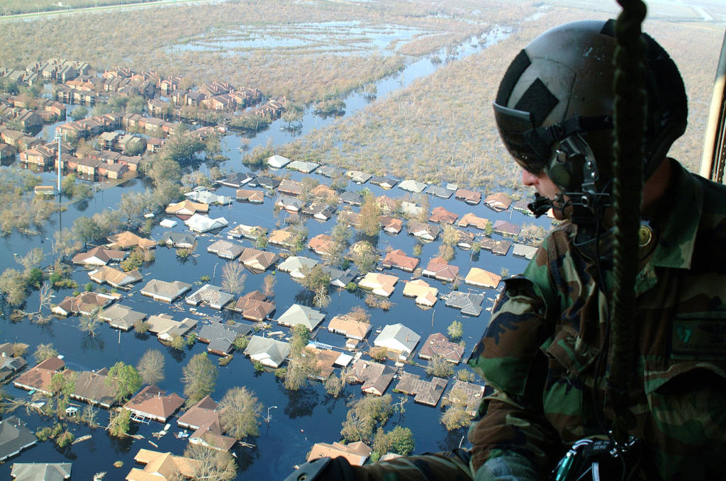 National Guard Sgt looks down into flooded streets searching for survivors. He is part of an Air Force Reserve team credited with saving more than 1,040 people in the aftermath of Hurricane Katrina.