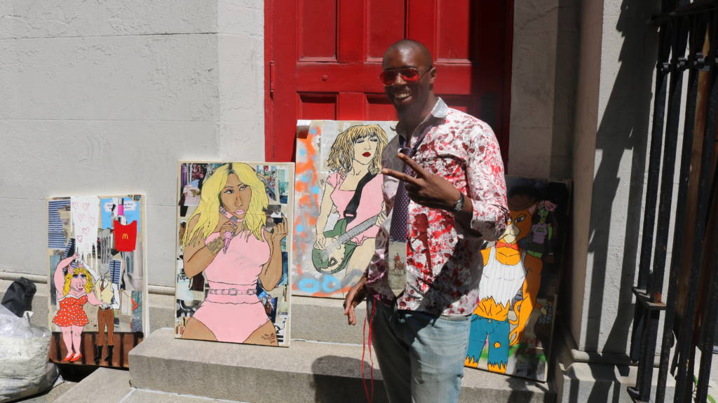 Dele Akerejah stands in front of some of his artwork.