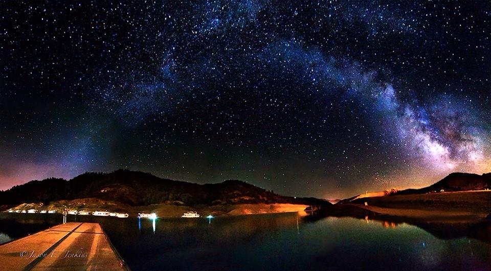 A photo illustration of the cosmos above a cityscape