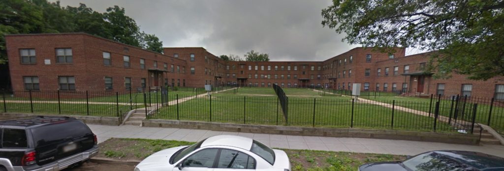 Photo showing multiple apartment buildings in a fenced-off complex