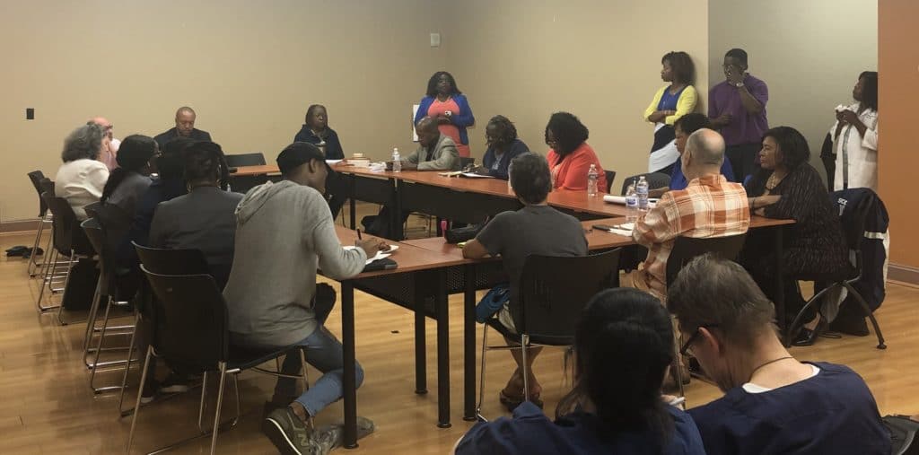 Participants sitting around a table at the meeting in a UMC conference room