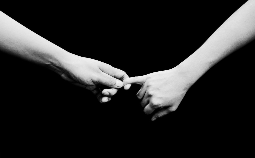 Two hands reaching toward each other