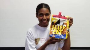Portrait photo of Connie Porter holding up a bag of cat litter