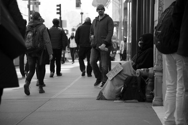 Black and white photo of a homeless man on the street