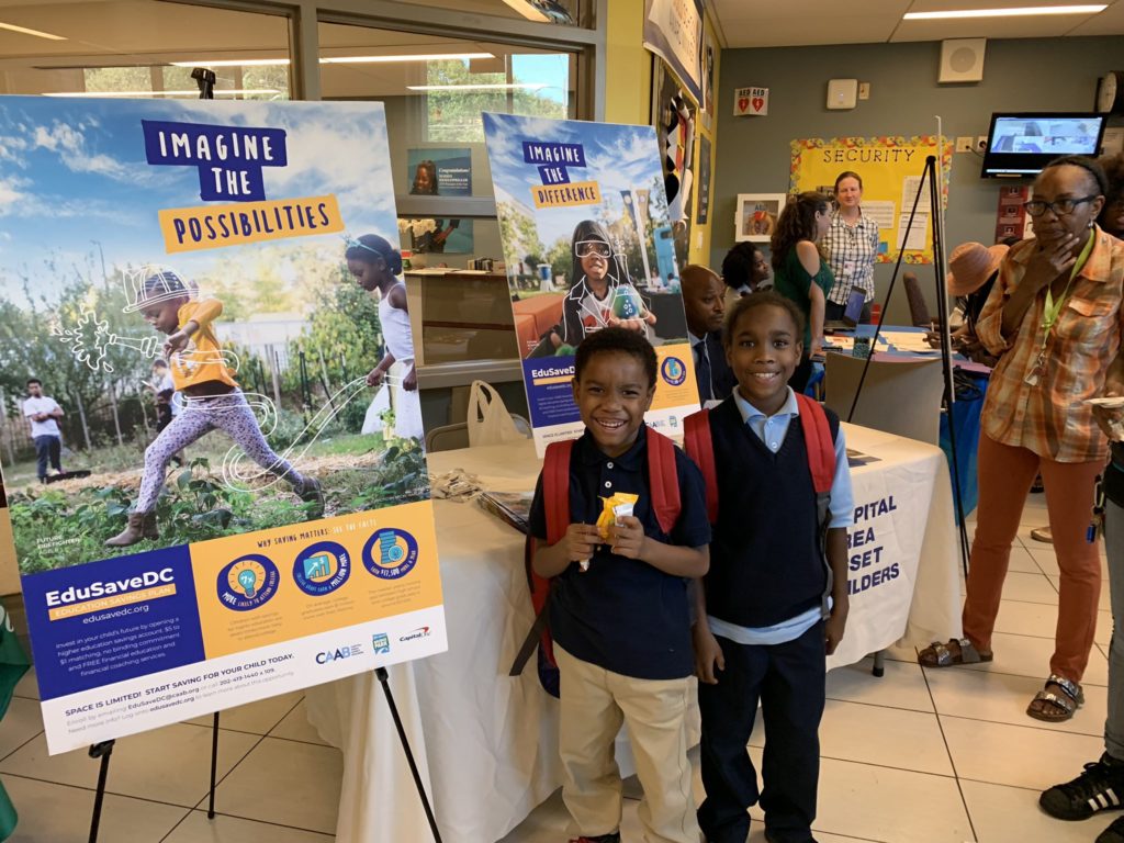 Photo showing two children standing in front of an EduSaveDC poster.