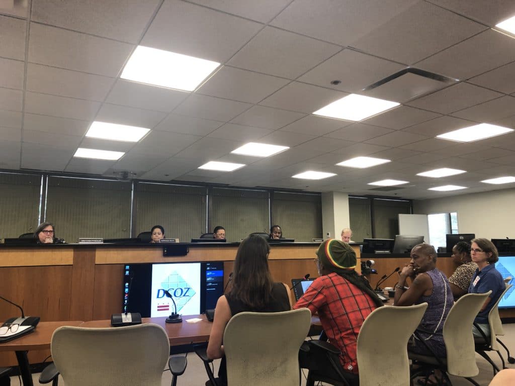 Image of several people at a hearing.
