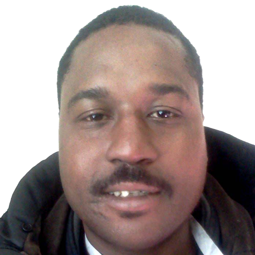A man with a mustache looks at the camera