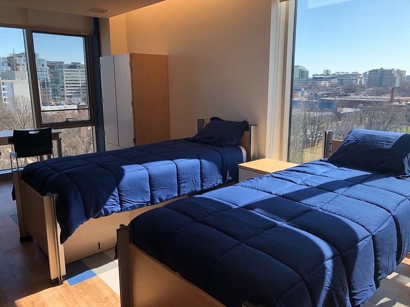 Two twin sized beds in a brightly lit room 