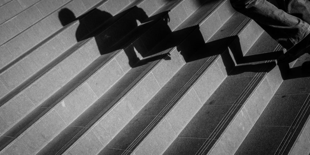 A shadow of a person cast over some steps.