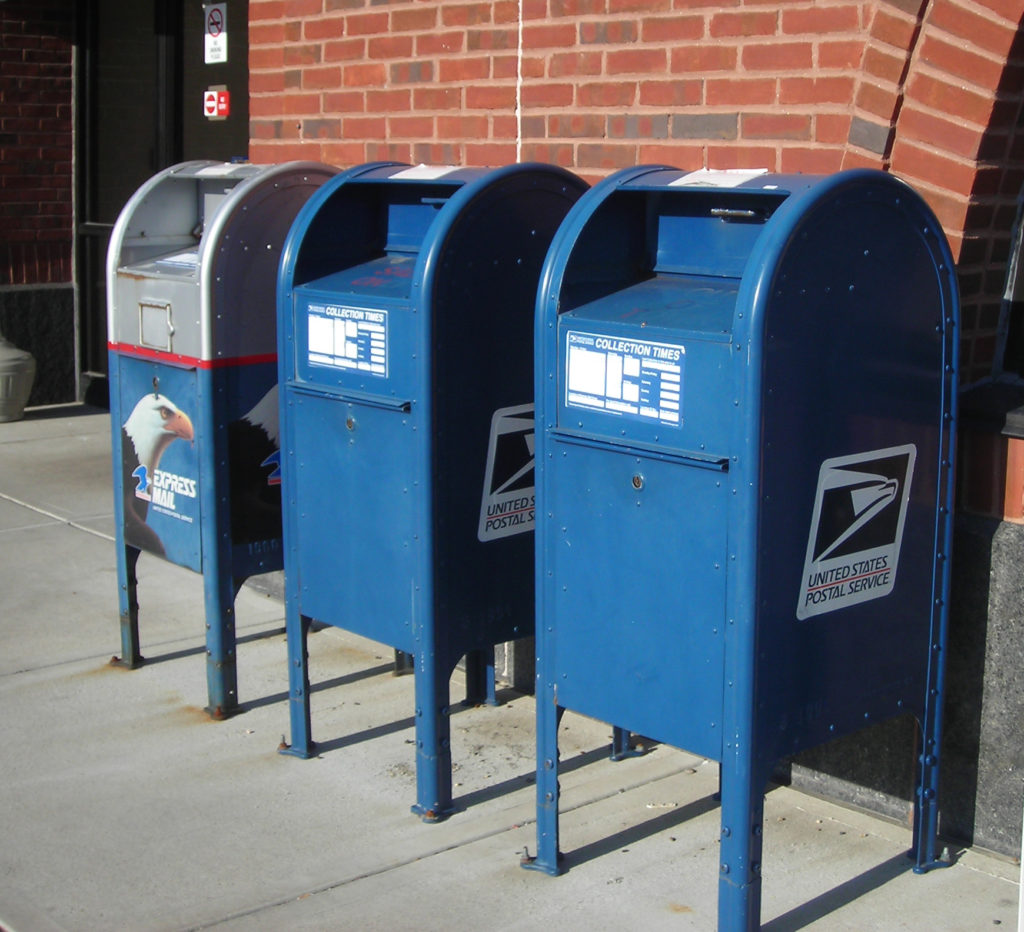 Three blue post boxes lined up in a row