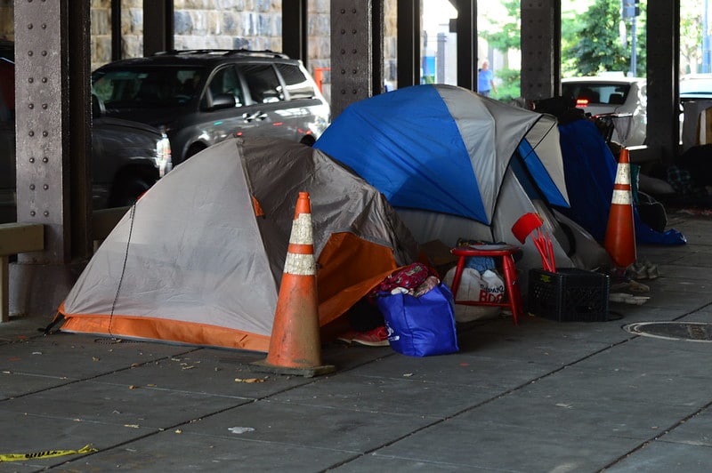 Tents under a freeway overpass.