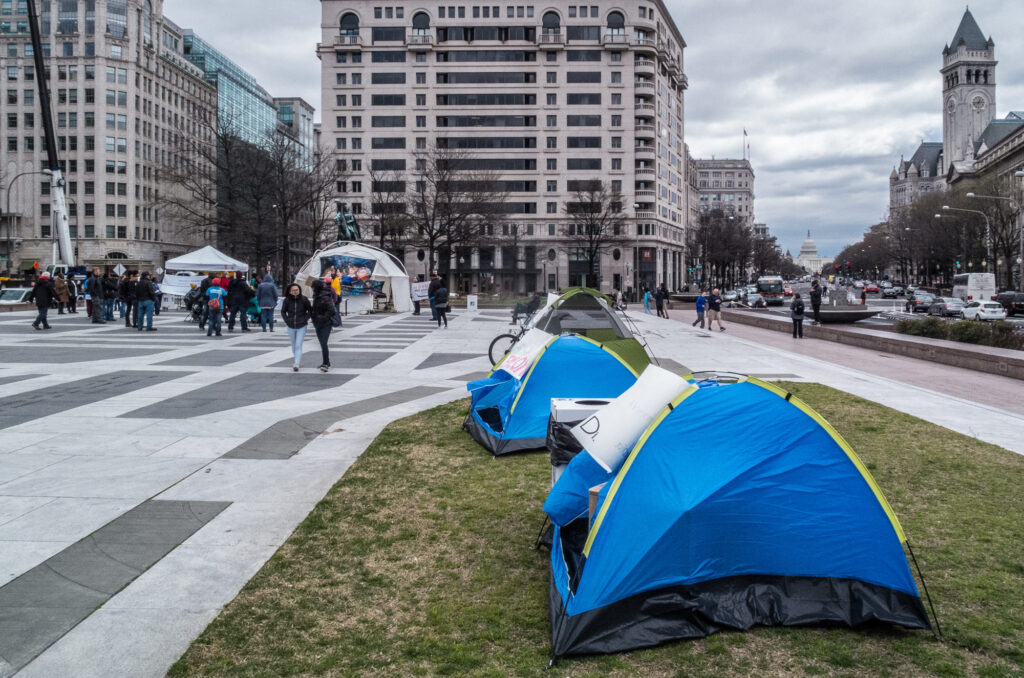 An image of tents in front of a large plaza.
