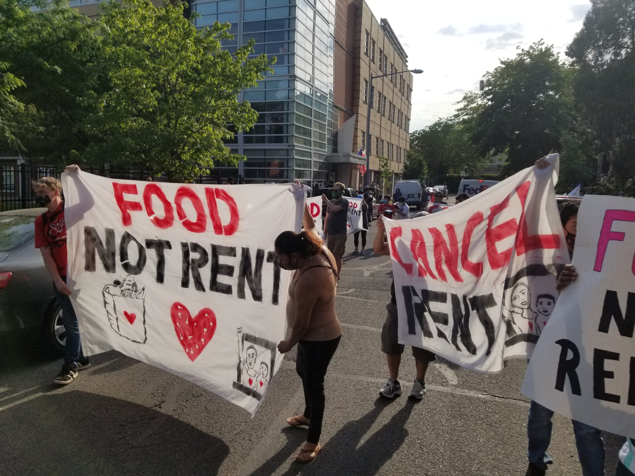 Photo of people holding up banners that read "food not rent" and "cancel rent"