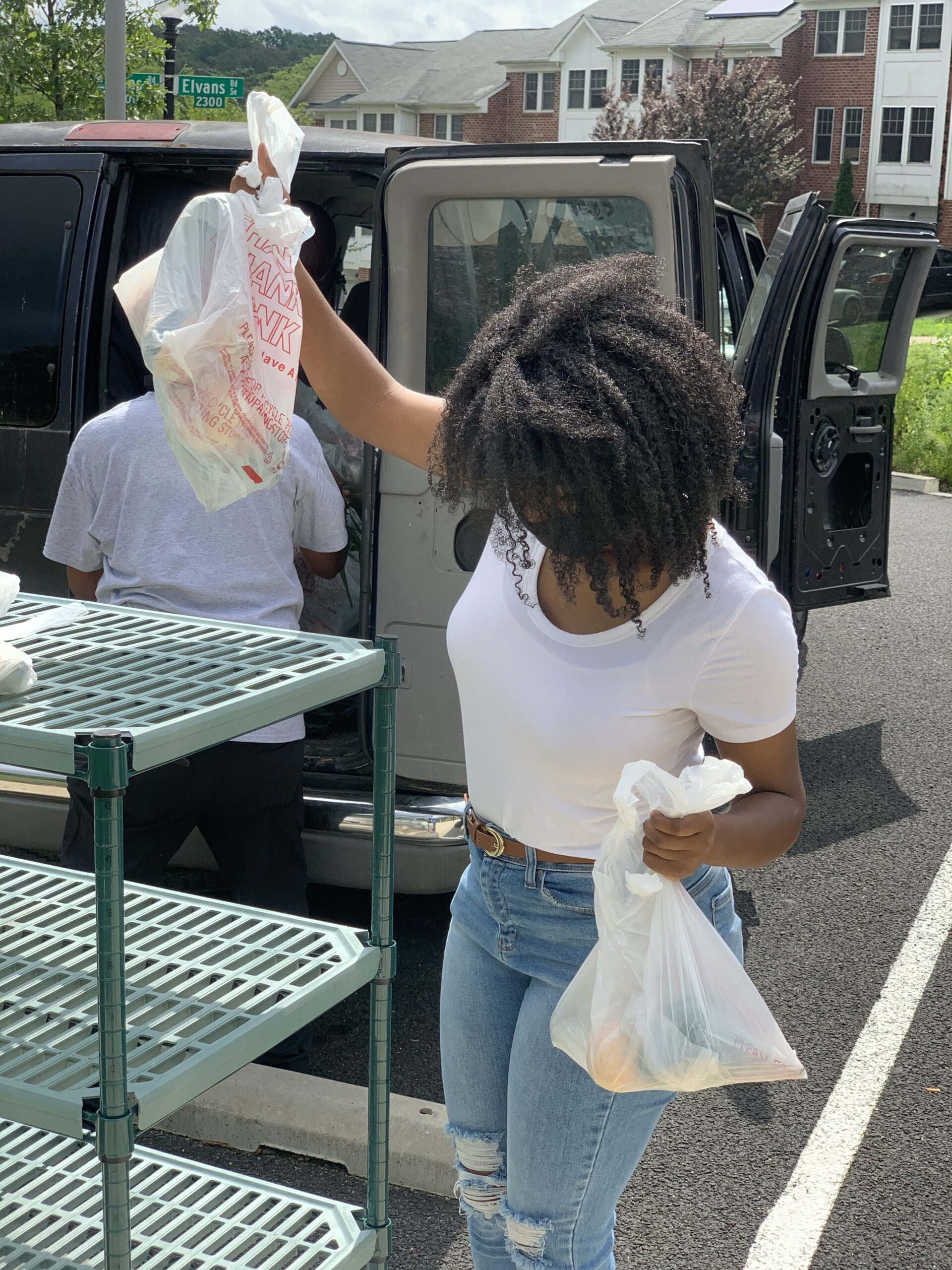 A Black women holds two shopping bags. 