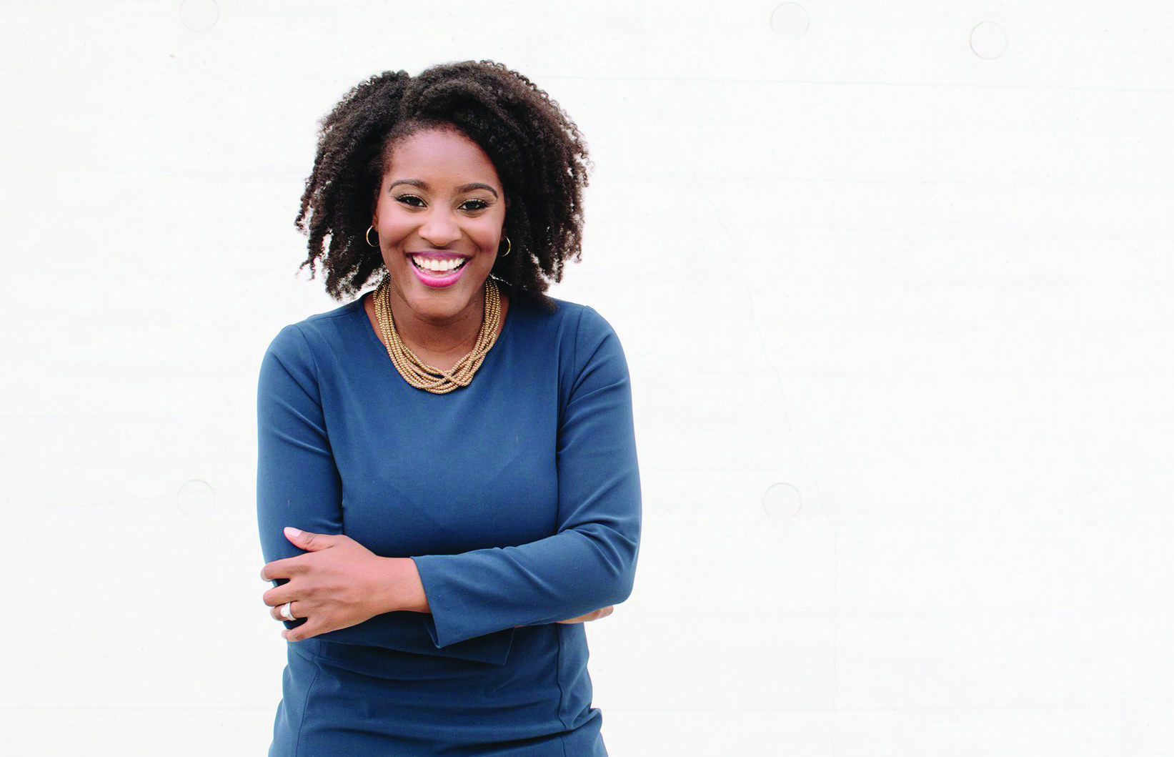 Christina Henderson standing with her arms crossed and a smile, with the words "Christina Henderson DC Council At-Large".