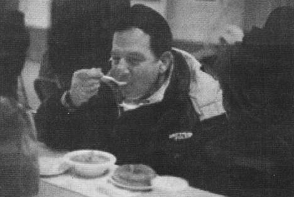 A man eats a bowl of soup.