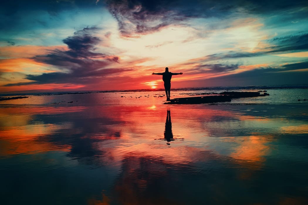 A man standing in front of a sunrise.