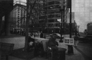 A photo of a bench on a busy street. 