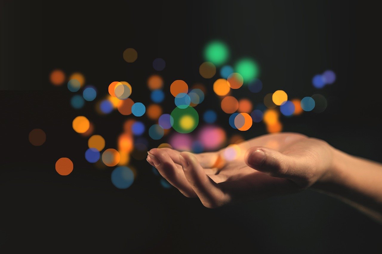 An image of an outstretched hand, empty, but with lights circling above