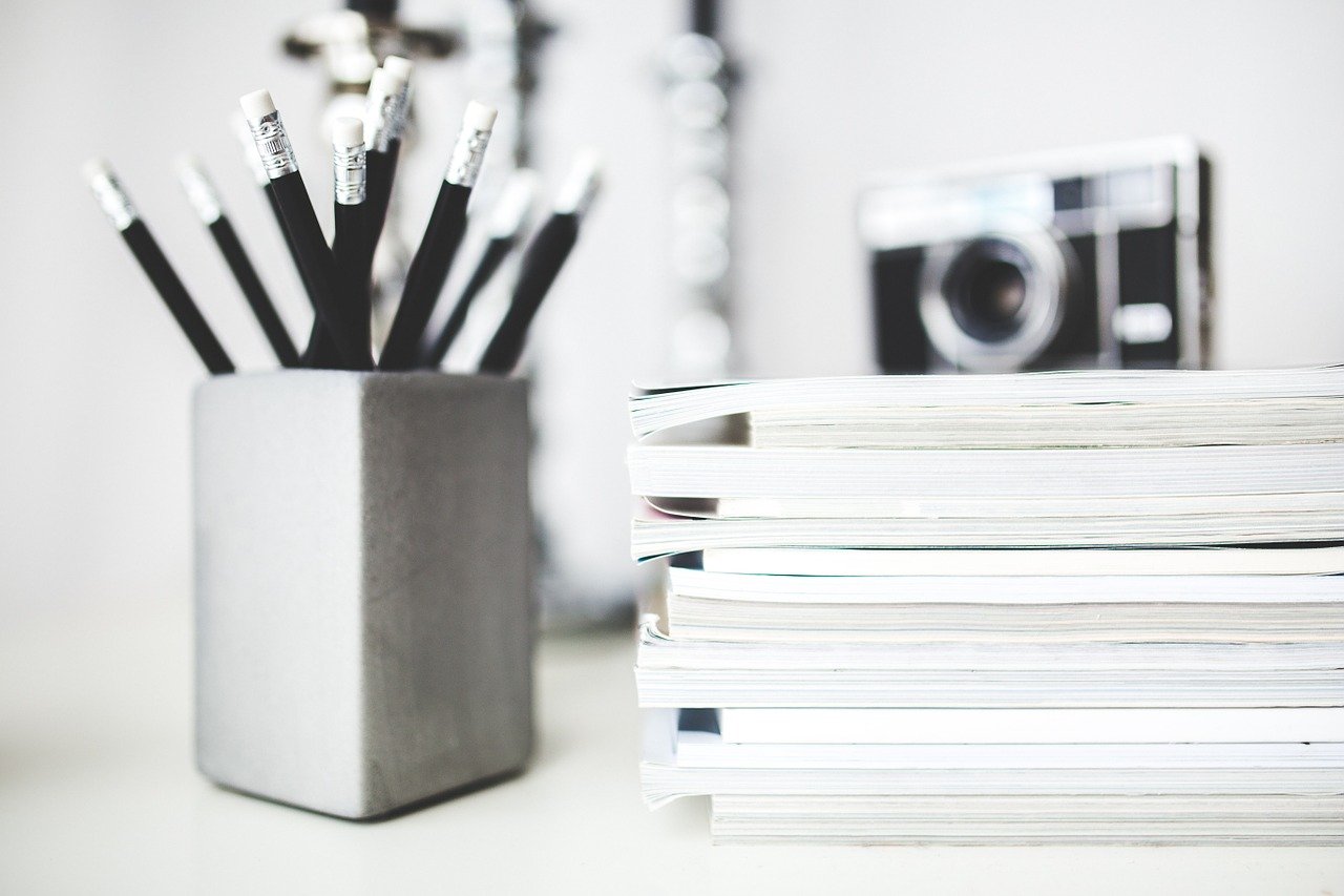 Picture of pencils in a container next to journals
