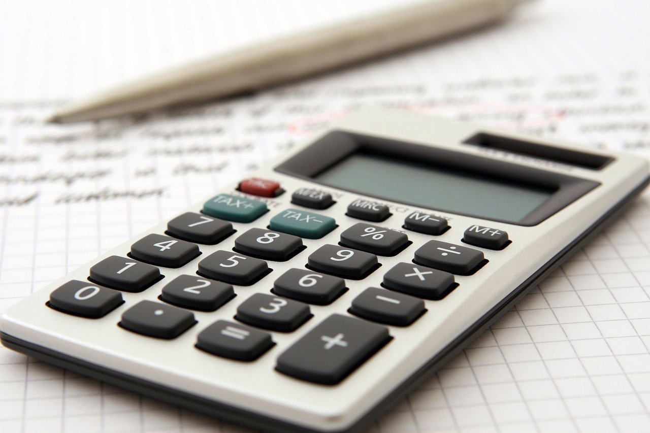 Photo of a calculator, pen, and paper.