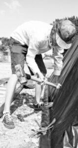 Photo of a man setting up a tent.