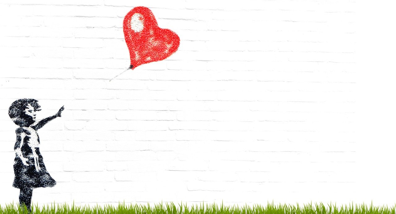 Photo of a mural depicting a young girl releasing a heart shaped balloon into the air