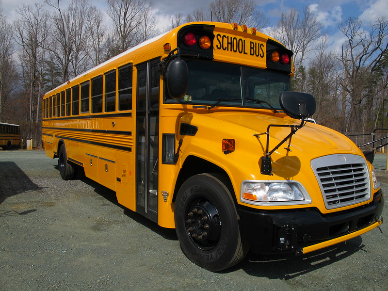 A photo of a brand new yellow school bus.
