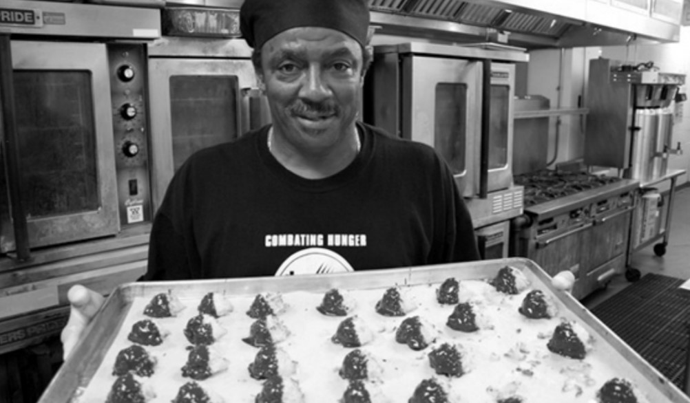 Photo of Darnell Herndon holding a tray of macaroons.