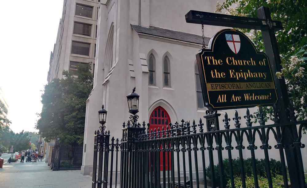 Phtoto of the church building. A sign in front of it says "The Church of the Epiphany, Episcopal/Anglican, All are welcome!"