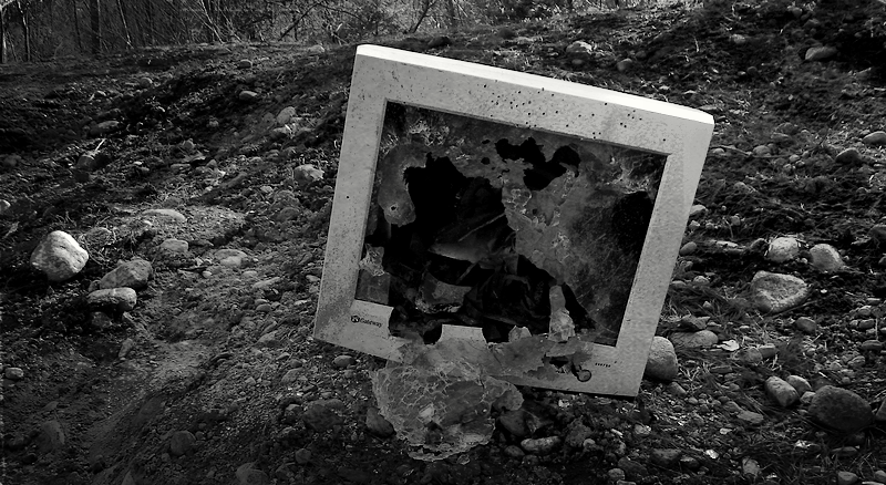 A black and white photo of a smashed computer monitor.