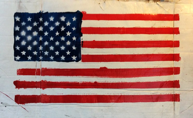 An artistic rendition of the US Flag, which has been painted onto the surface of cardboard
