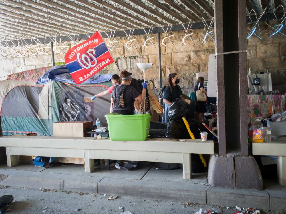 Photo of volunteers and nonprofit employees helping relocate residents from their encampment