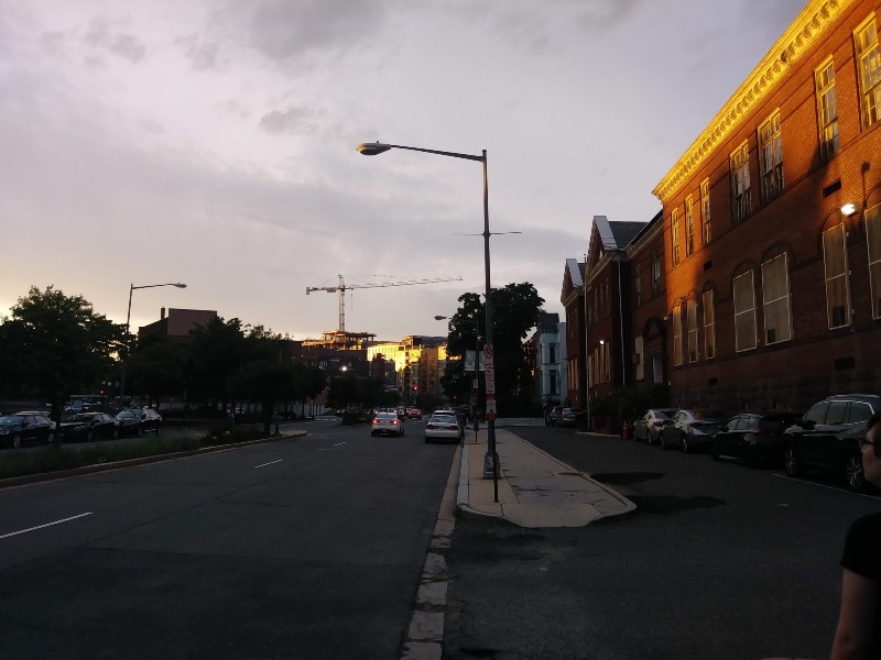 A street view towards U Street, where towering cranes are visible across the horizon.