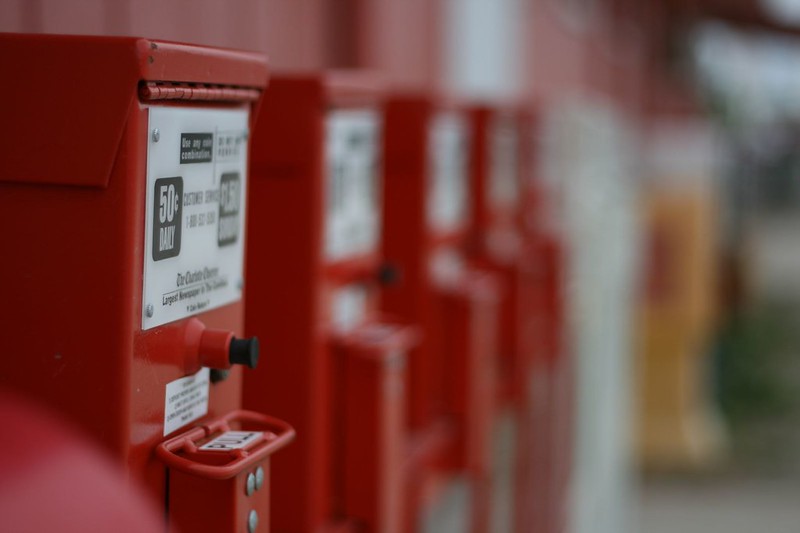 Photo of newspaper bins lined up on a street
