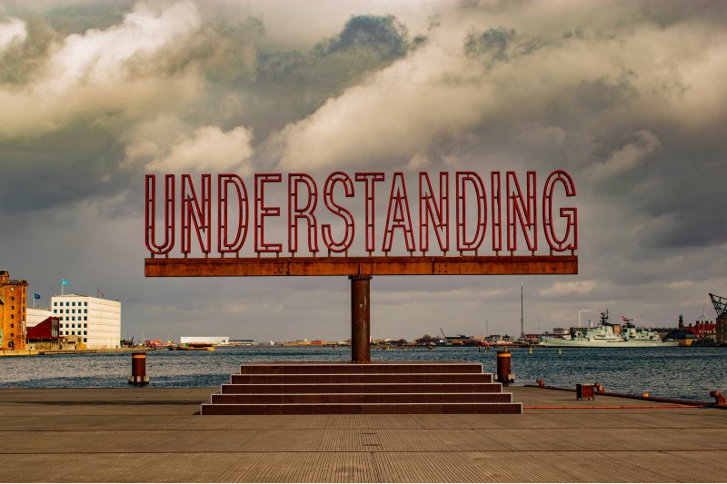 Photo of a metal sculpture that says the word "understanding"