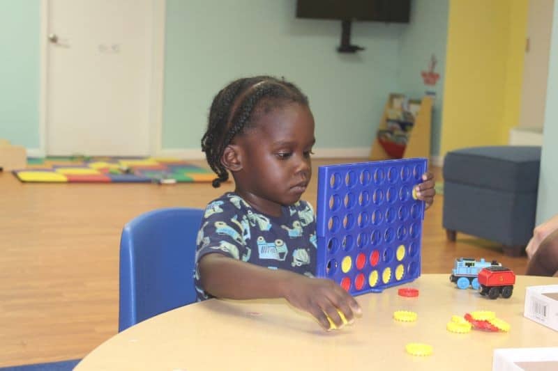 A child plays Connect 4 during an activity session